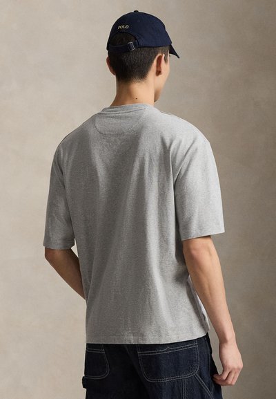 Γκρι κοντομάνικη μπλούζα με στρογγυλή λαιμόκοψη, κατασκευασμένη από μαλακό ύφασμα. Διαθέτει άνετη εφαρμογή και πλευρικές σχισμές για ευκολία στην κίνηση.