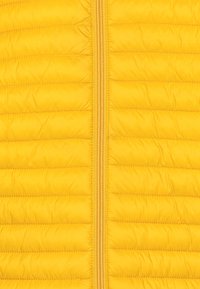 Gelbe gepolsterte Jacke mit horizontaler Steppung, ausgestattet mit einem zentralen Reißverschluss und glatter Textur. Leicht und in lebhaftem Farbton.