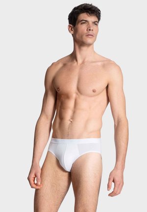 Weiße Baumwollunterhose mit glatter Textur, ausgestattet mit einem Logo-Bund und einem figurbetonten Design, präsentiert von einem Model vor einem neutralen Hintergrund.