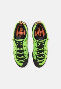 Des chaussures d'escalade vertes et noires dotées d'une tige en mesh avec des lacets contrastants, un orteil arrondi et des semelles en caoutchouc pour une meilleure adhérence. Des accents orange remarquables.