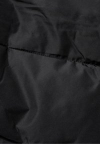 Czarny izolowany materiał o gładkiej fakturze i matowym wykończeniu. Widoczne szwy i detale przeszyć wzdłuż krawędzi.