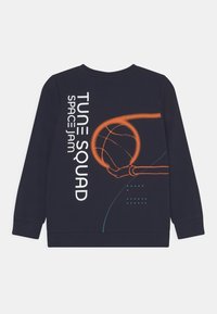 Sudadera azul marino con el texto "Tune Squad Space Jam" y un contorno naranja de una mano sosteniendo un baloncesto en la parte posterior.