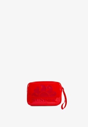 Bustina rettangolare rossa lucida con cinturino da polso, logo sole in rilievo e scritta "SUNDEK" sul davanti.