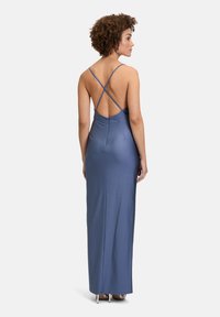Lang, aansluitend jurkje van zachtblauwe stof met kruislings geplaatste bandjes en een open rug. Gladde textuur met een lichte glans. Vloerlange stijl.