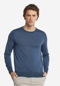 Blå långärmad tröja i ett lätt, mjukt stickat tyg med rund halsringning och ribbade ärmslut och nederkant. Minimalistisk design.