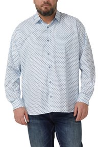 Hellblaues Hemd mit Knöpfen vor weißem Hintergrund, mit Diamantmuster, langen Ärmeln und einer Brusttasche. Wird mit dunklen Jeans getragen.