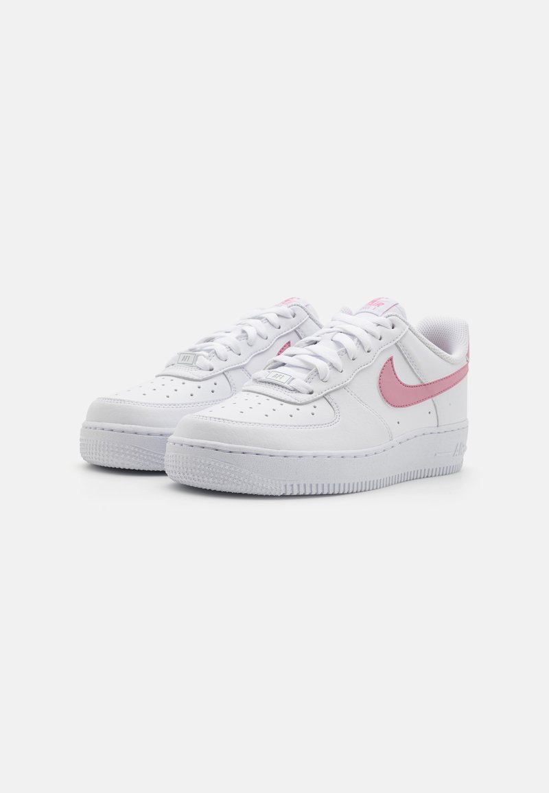 Sneakers bianchi in pelle con uno swoosh rosa, punta rotonda e suola in gomma testurizzata con perforazioni per la traspirabilità.