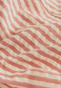 Tissu doux avec des rayures horizontales rouges et blanches alternées, légèrement froissé et texturé.