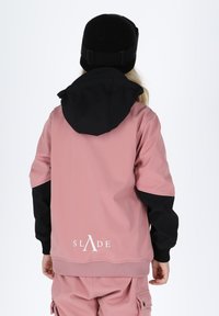 Pink og sort hættejakke med en glat tekstur. Har et mærke logo på ryggen og ribbede manchetter. Fuldfør looket med matchende bukser.