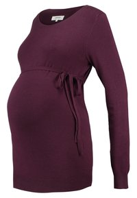 Bluzka ciążowa w głębokim fioletowym kolorze, z długimi rękawami, okrągłym dekoltem, wyposażona w związany w pasie detal dla regulacji, miękka dzianinowa tekstura.