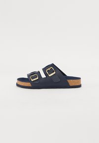 Marineblå sandaler med to justerbare stropper og guldtonede spænder. Kork sål med en tekstureret bund for greb og komfort.