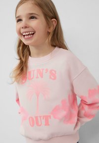 Lichtroze sweatshirt met een witte palmboom graphic; "SUN'S OUT" in vetgedrukte roze letters; zachte stof, ontspannen pasvorm met geribbelde boorden.