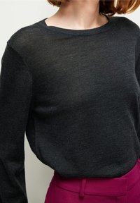 Tummanharmaa, kevyt neulospaita, jossa pyöreä pääntie, väljä malli ja pitkät hihat, sileällä pinnalla.