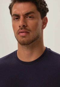 Granatowa teksturowana koszulka z okrągłym dekoltem, z prążkowanym wzorem, o dopasowanym kroju i gładkiej tkaninie, z subtelnym wykończeniem dekoltu.