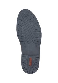 Suela de goma negra con un patrón texturizado, con surcos y crestas para mayor tracción. Talón reforzado con un detalle de marca en rojo.