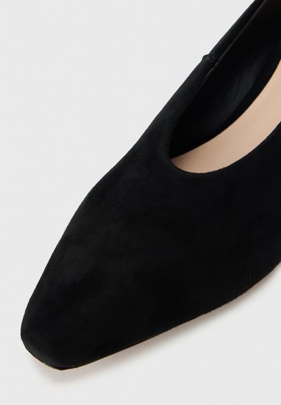 Μαύρα μπαλαρίνια από σουέντ με μυτερή μύτη και λεία εσωτερική επένδυση, με σχεδιασμό κοψιμάτων για αναπνοή και κομψότητα.