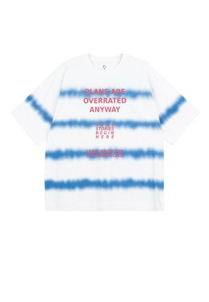 Biała koszulka z poziomymi niebieskimi paskami tie-dye i czerwonym tekstem: „Plany i tak są przeceniane”, „Niektóre historie zaczynają się tutaj” oraz „Zostaw miejsce na nieoczekiwane.”