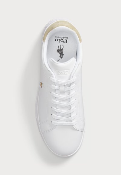 Valge Polo Ralph Laureni tennis, valged paelad, beežist seemisnahast kand, must polo mängija logo sisetaldal ja küljel.