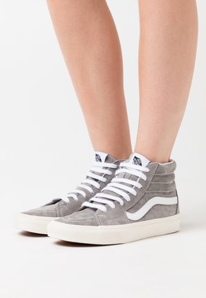 Wysokie sneakersy wykonane z szarego zamszu z białymi akcentami, posiadające sześć przelotek, płaskie białe sznurówki oraz teksturowany kołnierz.