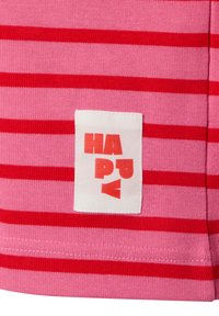 Gestreifter pinker und roter Stoff zeigt ein weißes Etikett mit dem Wort "HAPPY" in fettgedruckten roten Buchstaben, das eine weiche, strukturierte Oberfläche aufweist.