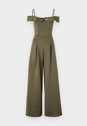 Salopetă de culoare verde măsliniu, cu umeri goi, bretele subțiri, corset ajustat și pantaloni largi. Prezintă pliseuri și un sistem de închidere prin legare la spate.