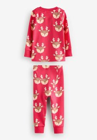 Ensemble de pyjama en coton rouge avec un motif de renne. Comprend un haut à manches longues et un bas assorti avec des poignets côtelés.