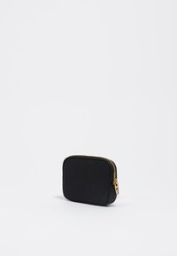 Bolsita de tela negra con forma cuadrada, cremallera dorada y textura sutil. Diseño compacto adecuado para guardar objetos pequeños.