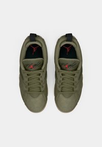 Par de zapatillas de ante verde oliva con plantillas negras que presentan el logo rojo de Jumpman y el texto "Flight" en la lengüeta, vistas desde arriba.
