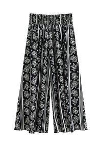 Pantalons larges à motifs noir et blanc avec une taille élastique. Présente des imprimés floraux et géométriques sur un fond rayé.