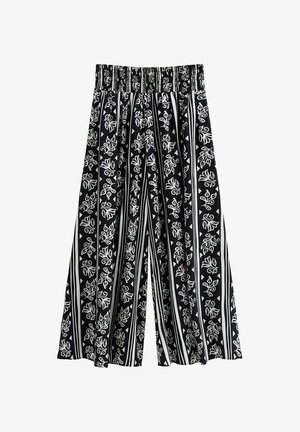 Black and white patterned wide-leg pants with an elastic waistband. Features floral and geometric prints on a striped background.