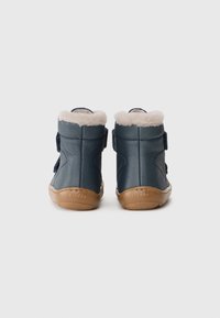 Marineblauwe leren enkellaarsjes met een zachte beige voering, twee verstelbare riemen en een tanrubberen zool, met gestructureerde zijkanten en stikdetails.