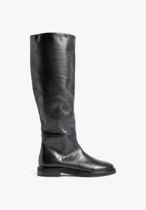 Botte noire montante en cuir lisse, dotée d'un bout arrondi et d'un petit talon empilé avec des détails de couture minimaux.