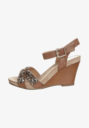 Bruine wedge sandaal met enkelband, met een bovenwerk van faux leer, een zachte suède binnenzool en versieringen van heldere rhinestones aan de voorkant.