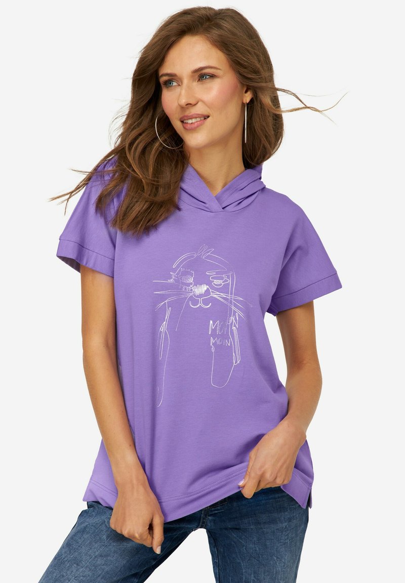 Camiseta de estilo sudadera morada con mangas cortas, presenta un dibujo en línea blanca de un gato y el texto "Moin" en la parte frontal. Tela de algodón suave.