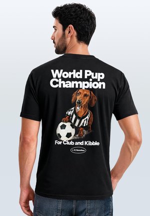 Mann, der ein schwarzes T-Shirt trägt, mit einem Hund im Schiedsrichterhemd, der einen Fußball hält, und Text "World Pup Champion For Club and Kibble".