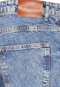 Jeans din denim albastru cu o etichetă din piele pe care scrie "2Y PREMIUM" la talie. Prezintă cusături vizibile și o buză de spate.