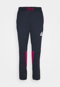 Marinen sweatpants med rosa detaljer, tillverkade av texturerat tyg. Har resårmidja med dragsko och en logotyp på vänster sida.
