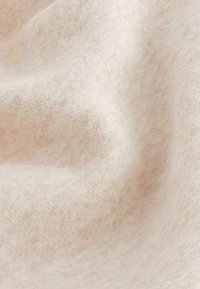 Tejido beige claro con una textura suave, que presenta un sutil patrón jaspeado y una superficie lisa, recogido y drapeado para darle profundidad.