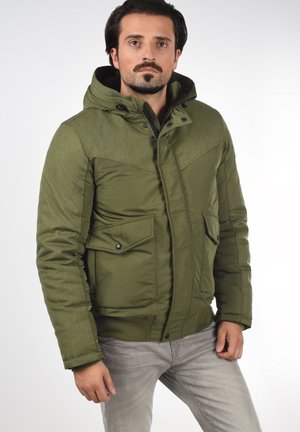 Olive green puffer jacket with a textured shoulder yoke, hood, front pockets, and snap closure. Smooth finish with reinforced seams.