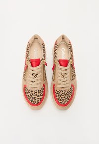 Sneakers beige con stampa leopardata, accenti rossi e lacci crema. Presentano cerniere laterali e una parte superiore texturizzata per un tocco di dettaglio in più.