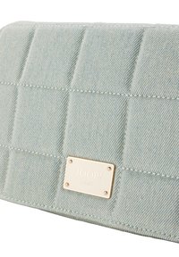 Prošívaná světle modrá denimová kabelka s kovovým logem v zlatém tónu s nápisem "JOOP! JEANS", s úzkým prošitím a hladkým povrchem.