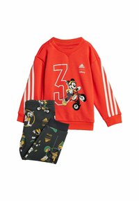 Felpa rossa con strisce bianche Adidas e design con il numero 3. Pantaloni neri con grafiche colorate dei personaggi Disney. Mix di cotone.