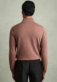 Pullover a maniche lunghe con colletto in morbido tessuto rosa polveroso, design aderente, polsini a coste, abbinato a pantaloni neri su misura.