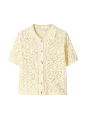 Roomkleurig gebreid kortemouwvest met een kantpatroon, knopen aan de voorkant en een kleine kraag.