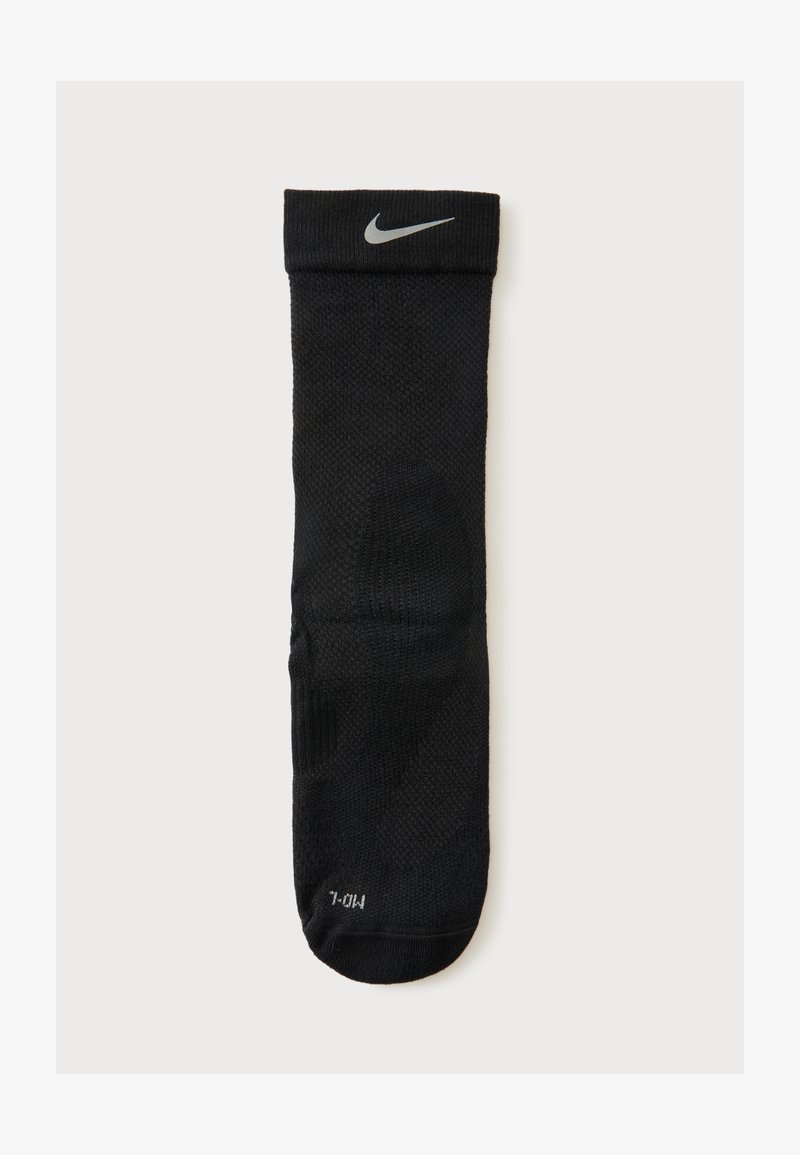 Μαύρη κάλτσα Nike crew με γκρι λογότυπο Swoosh κοντά στο μανσέτα και ένδειξη μεγέθους "M/L" στο δάχτυλο, εμφανίζεται σε λευκό φόντο.