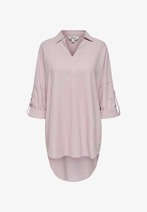 Heledane roosa särk V-kaelusega, üles veeretatud varrukatega ja kumerate äärtega. Valmistatud pehmest kangast, millel on sile tekstuur. Kaubamärgi silt on nähtav.