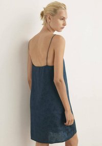 Abito senza maniche di un blu navy con un sottile motivo floreale, dotato di spalline sottili e un design con scollatura bassa. Tessuto di trama liscia.