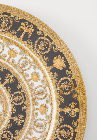 Πορσελάνινο πιάτο με μαύρο φόντο, διακοσμημένο με λεπτομερή χρυσά σχέδια, λουλουδένια μοτίβα και διακοσμητικά αγγεία κατά μήκος της άκρης.