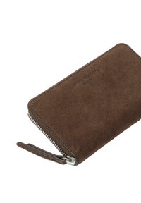 Brązowy portfel zamszowy z zamkiem błyskawicznym, o teksturowanej powierzchni i wytłoczonym logo. Kompaktowy, prostokątny kształt z uchwytem do pociągania.