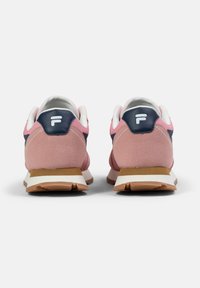Sneaker in suede rosa con accentuazione del tallone blu navy, logo bianco e suola in gomma leggera. Presenta un colletto imbottito e una tomaia testurizzata.